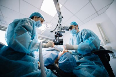 dentists performing a dental procedure on a patient.