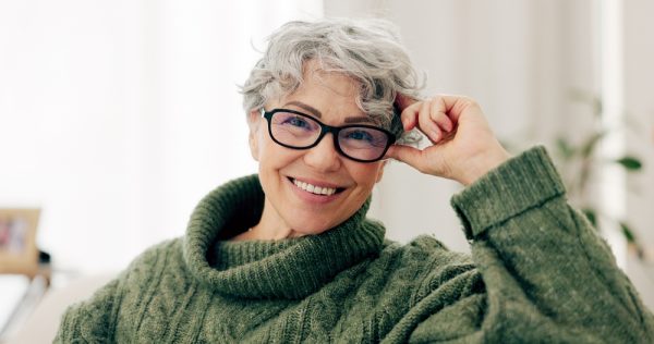 older woman in green sweater smiles