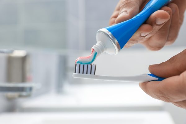 applying toothpaste to toothbrush