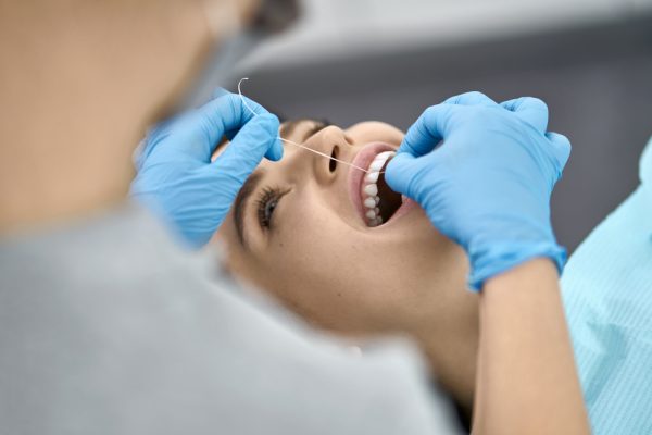 dentist flosses patient's teeth